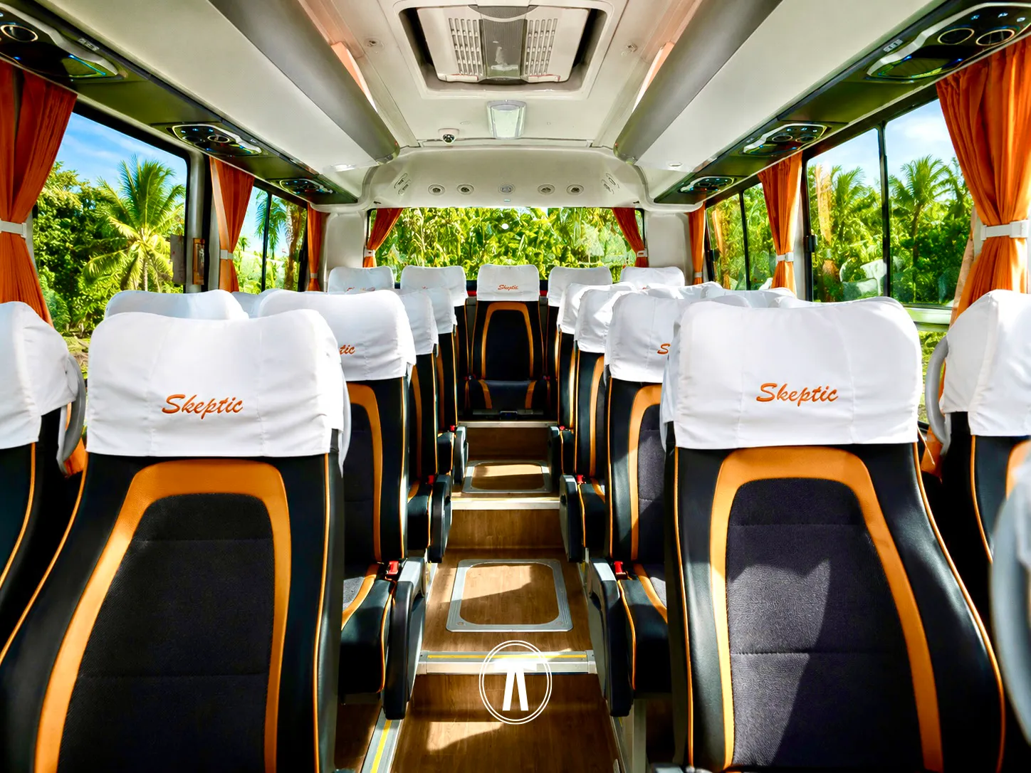 Interior of a Nakdar Transport coach, rows of seats facing the rear windows with tropical greenery visible outside